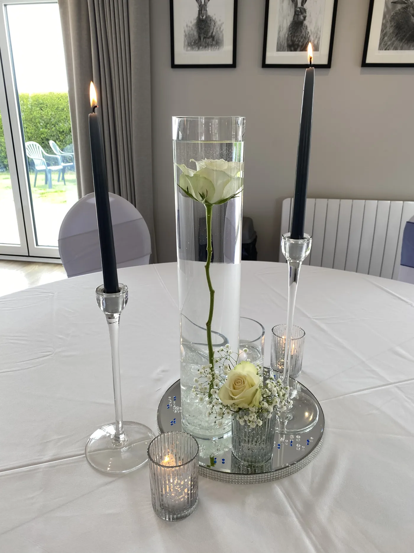 Candles and a single rose on a wedding table