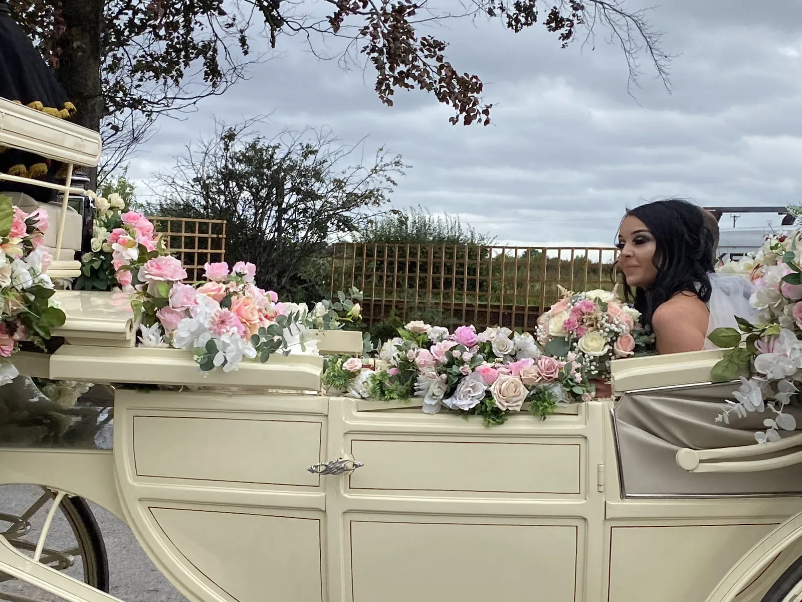 A bride arriving by flower-dressed carriage