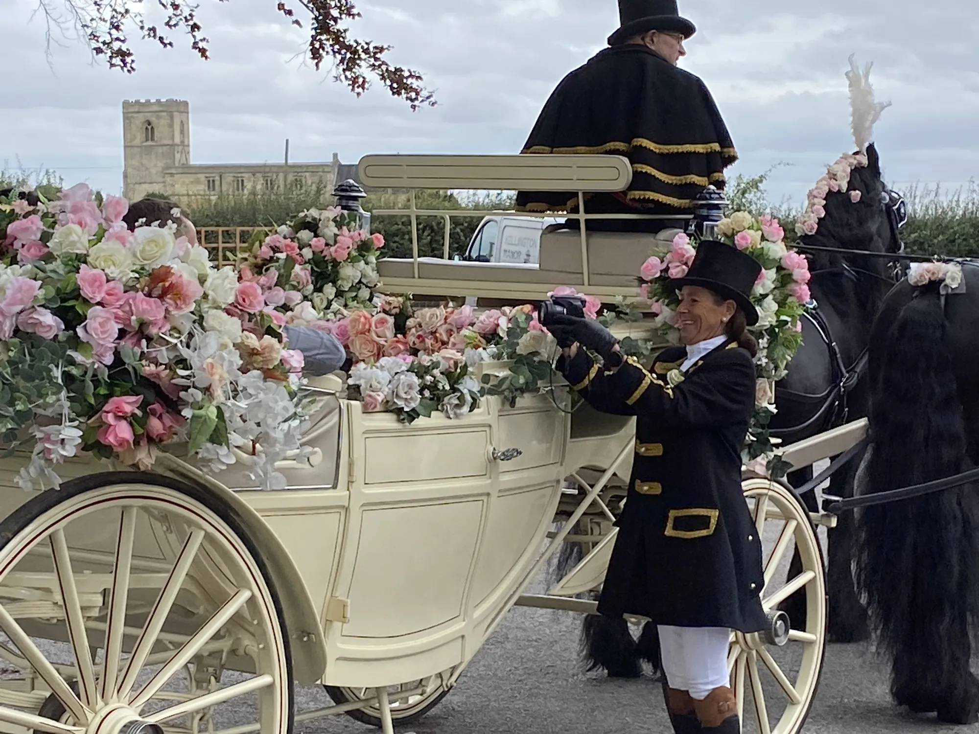 A horse-drawn carriage arriving at Kellington Manor, St Edmund’s tower behind