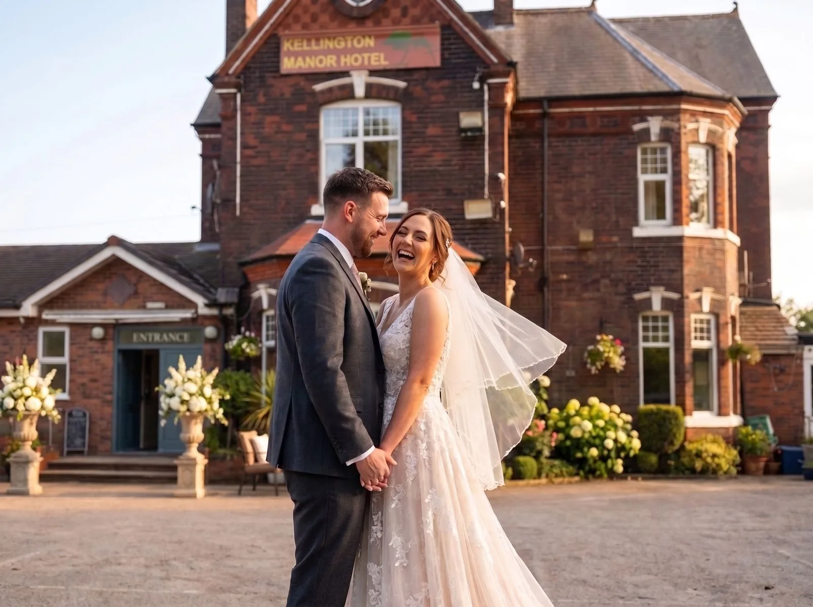 A bride and groom laughing together outside Kellington Manor in evening light